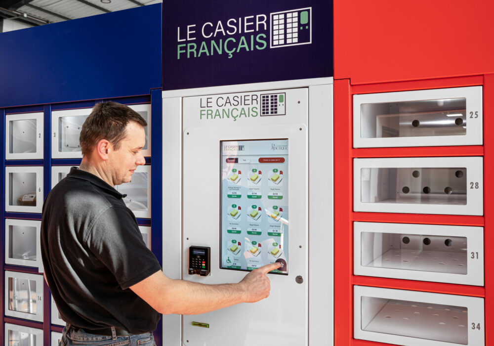 Directeur Industriel Le Casier Français en train d'utiliser la borne de commande du distributeur automatique