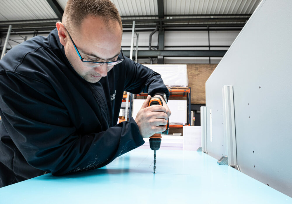 Technicien Le Casier Français en train d'assembler le distributeur automatique