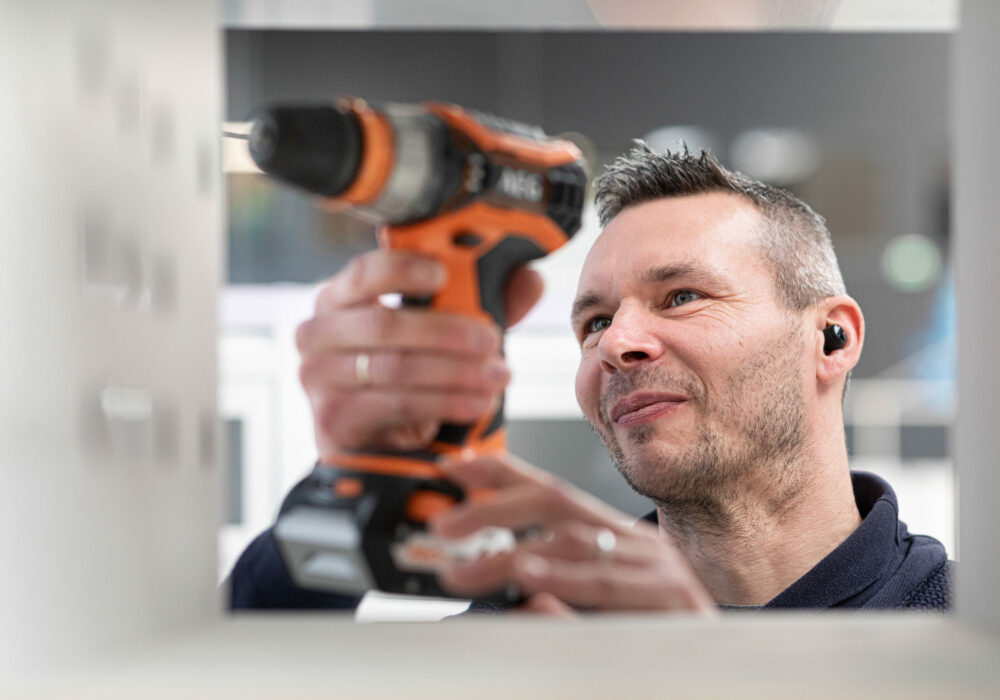 Technicien Le Casier Français en train de visser la structure du distributeur automatique