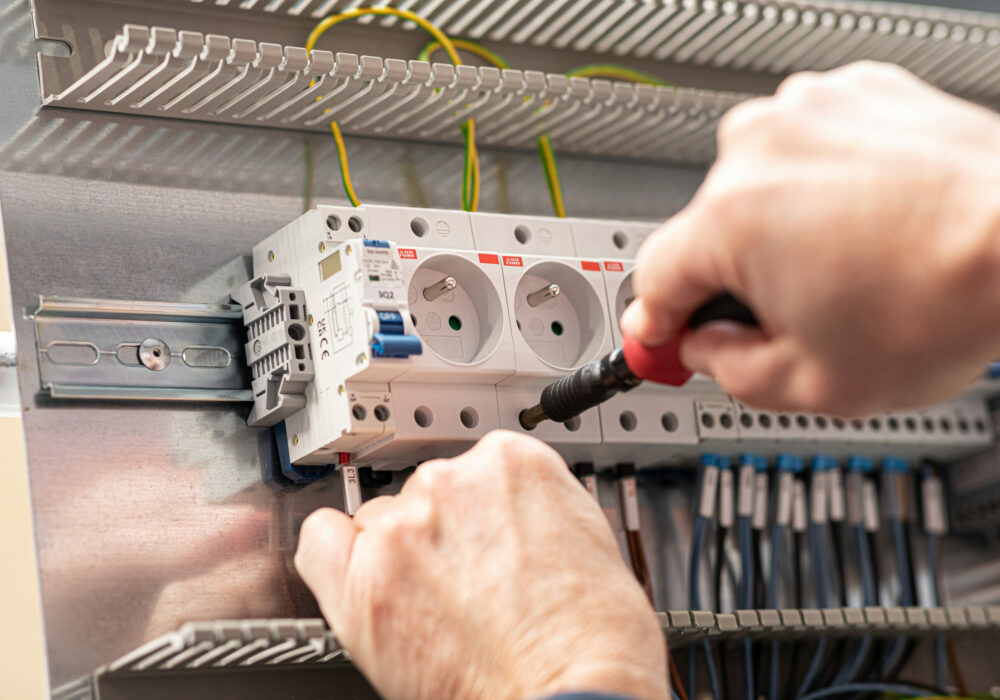 Technicien Le Casier Français en train de gérer l'électricité du distributeur automatique lors de la fabrication