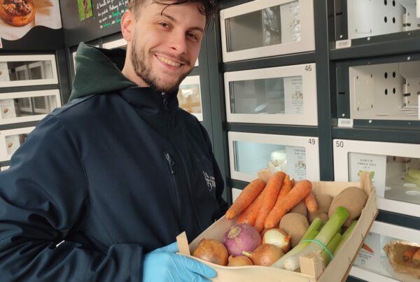 A delivery person restocks an Automat-e fresh food vending machine with fruit and vegetables.